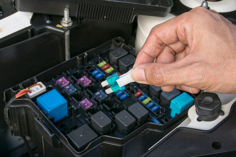 Auto mechanic removing a fuse