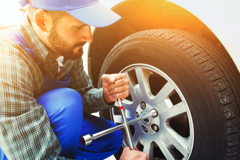 Man tightening a wheel after changing a car tire