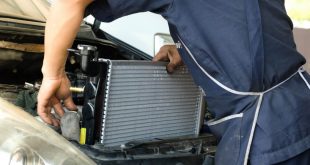Auto mechanic replacing a car radiator