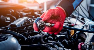 Auto mechanic repairing a car AC system