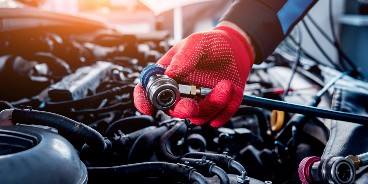 Auto mechanic repairing a car AC system