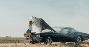 Woman in front of an overheating car