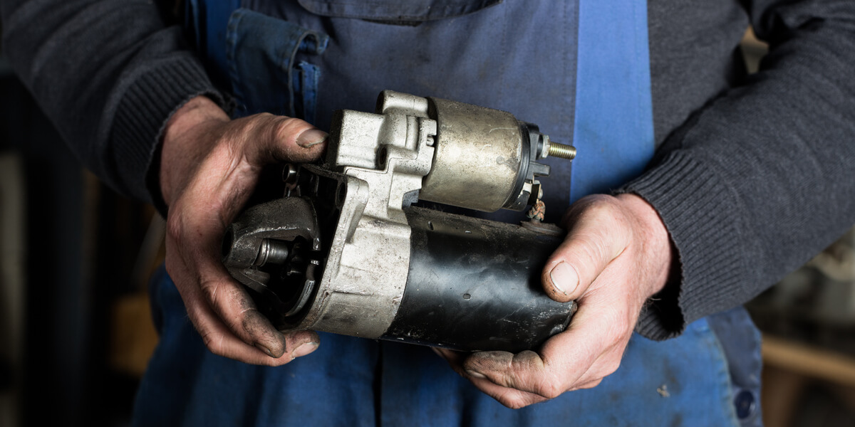 Auto mechanic replacing a starter