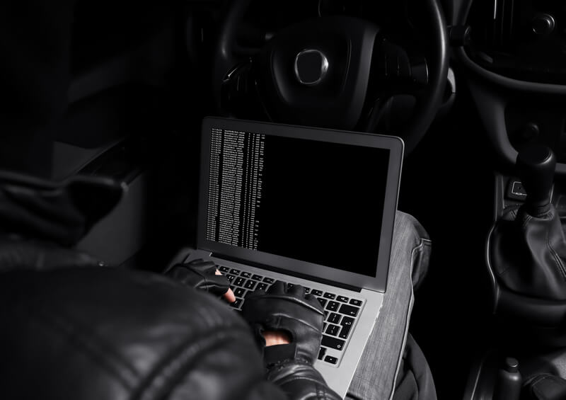 Car thief using a computer to start a car