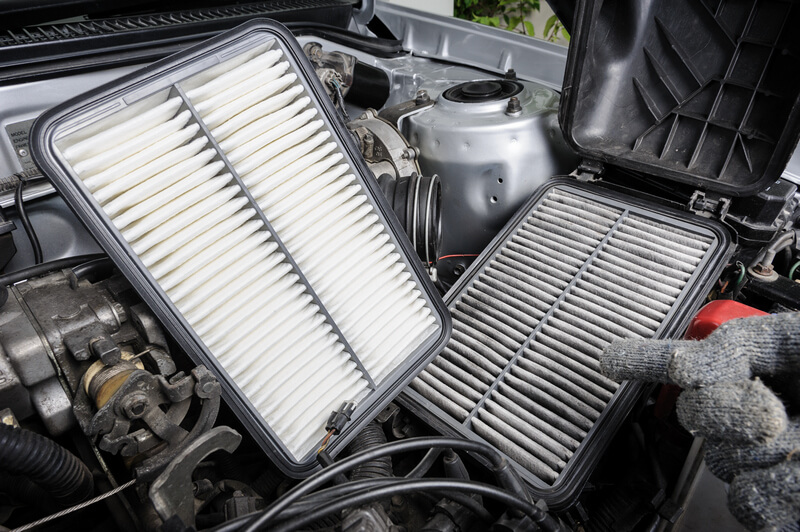 Auto mechanic replacing an air filter