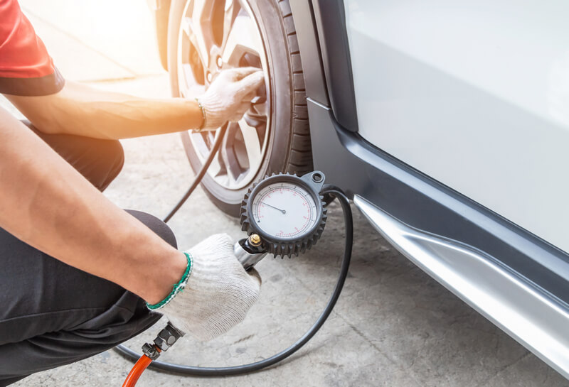 Auto mechanic adjusting tire air pressure