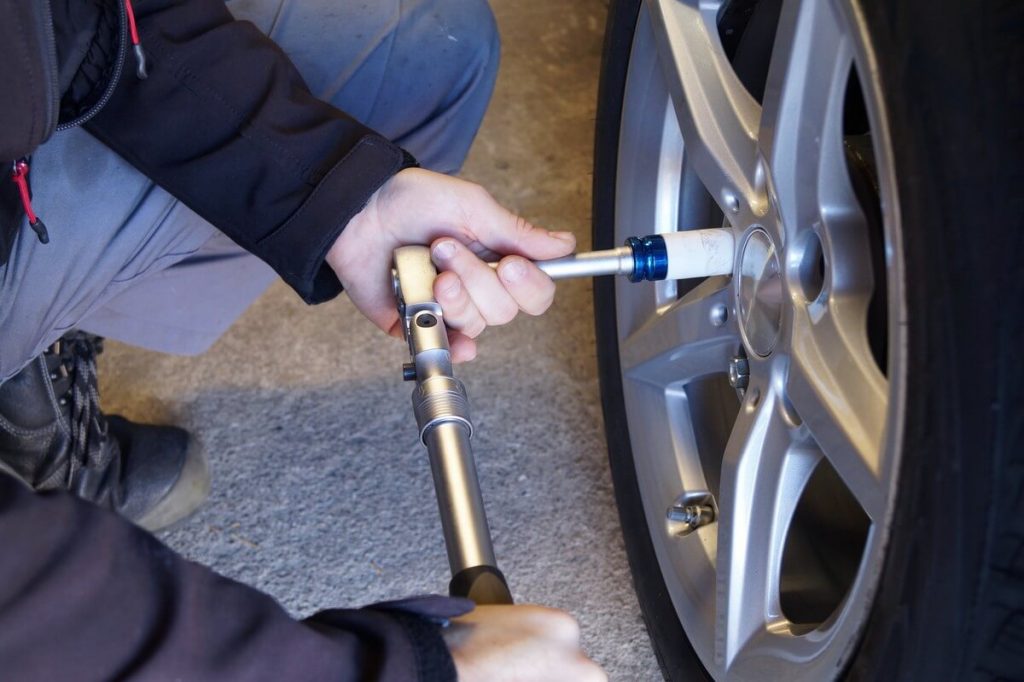 Auto mechanic installing wheel locks