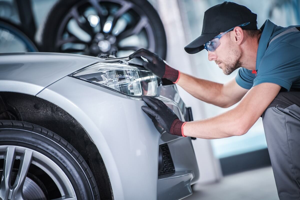 Mechanic adjusting headlights
