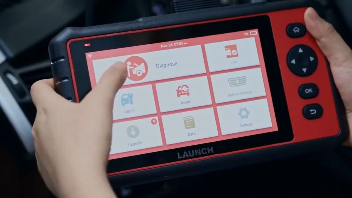 Auto mechanic using a Launch OBD2 scan tool