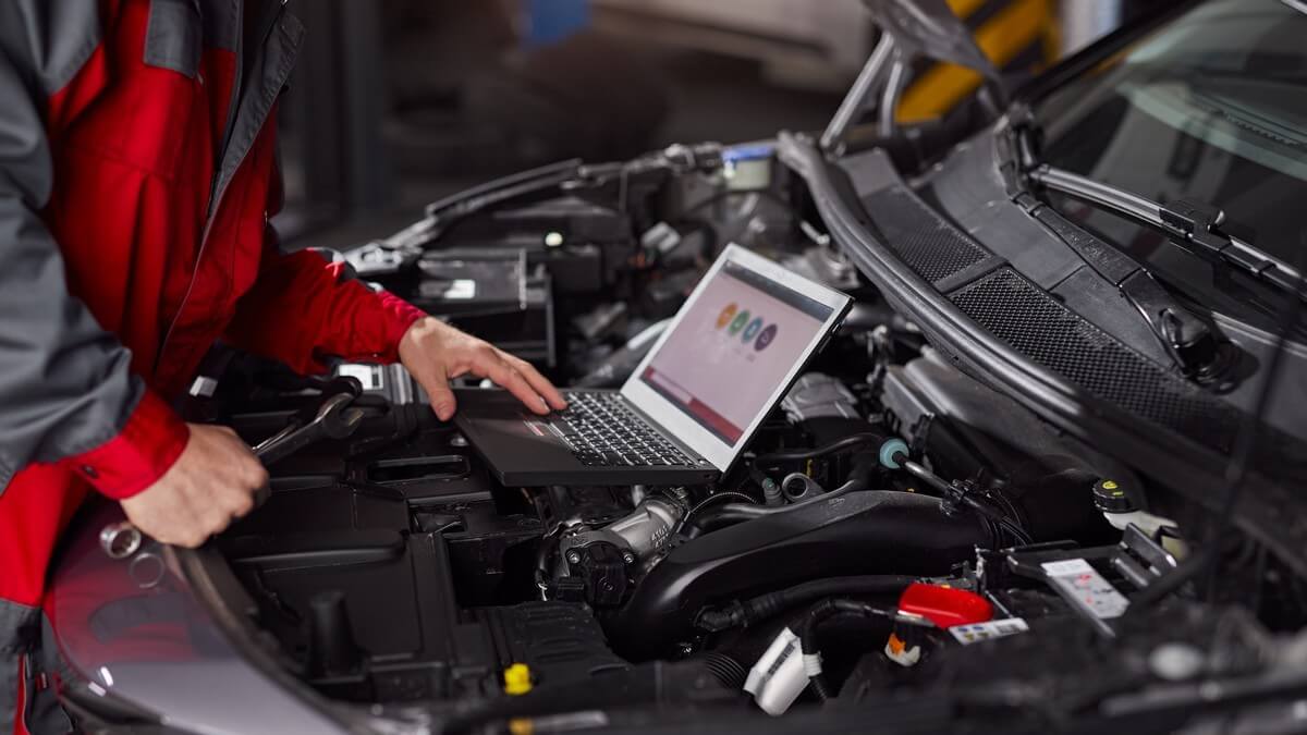 Mechanic using laptop to communicate with customers