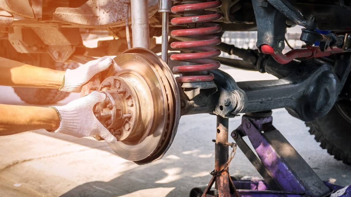 auto mechanic replacing disc brakes