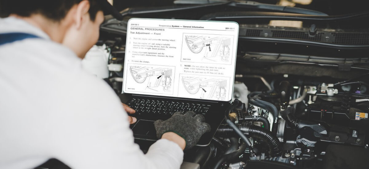 Auto mechanic working with repair manual