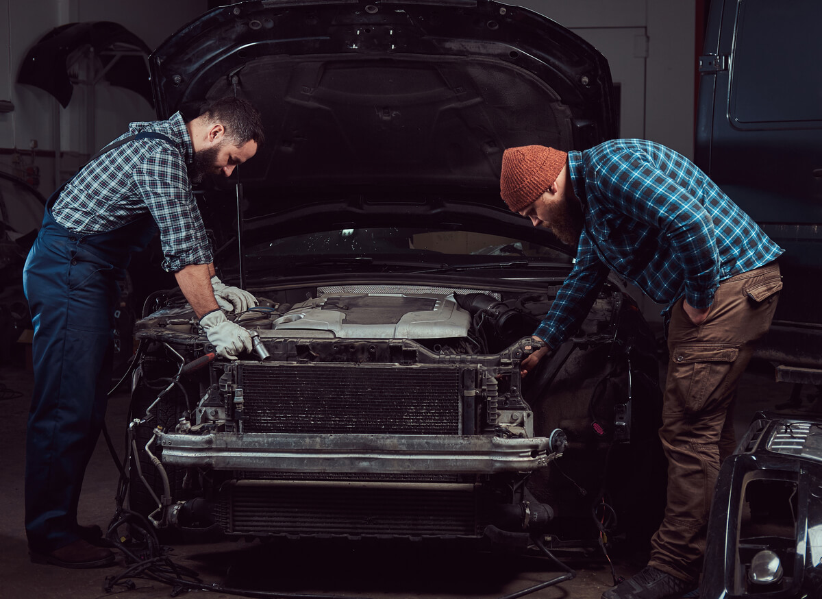 Two mechanics restoring an old car