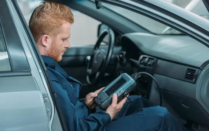 Auto mechanic using OBD2 scan tool