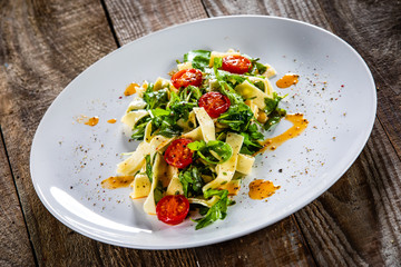 Pasta With Tomatoes And Arugula On Wooden Table Wall Mural Questions & Answers